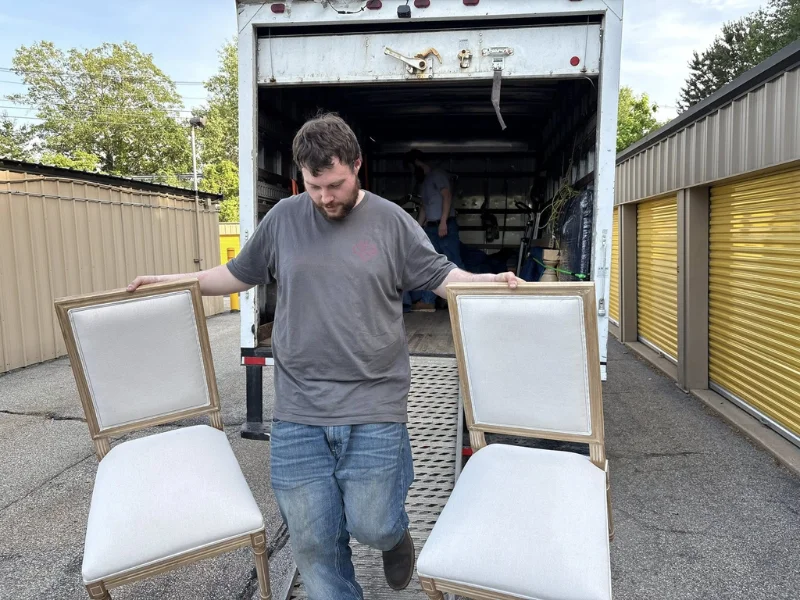 Image showing a professional unloading chairs from a truck.